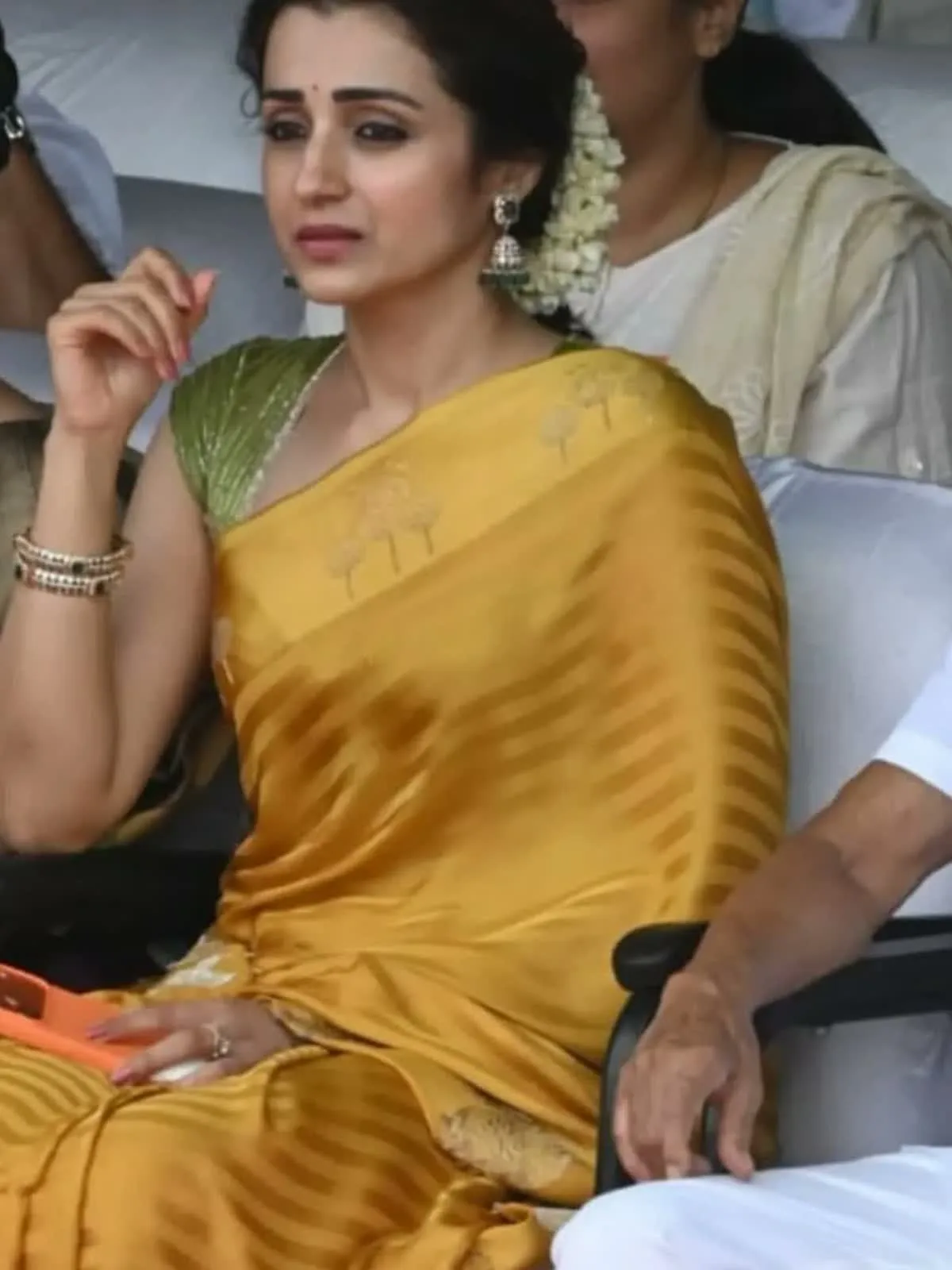 Trisha Krishnan — Seated — the broad self-tone stripes running through the pleats, and the bangles set with green stones
