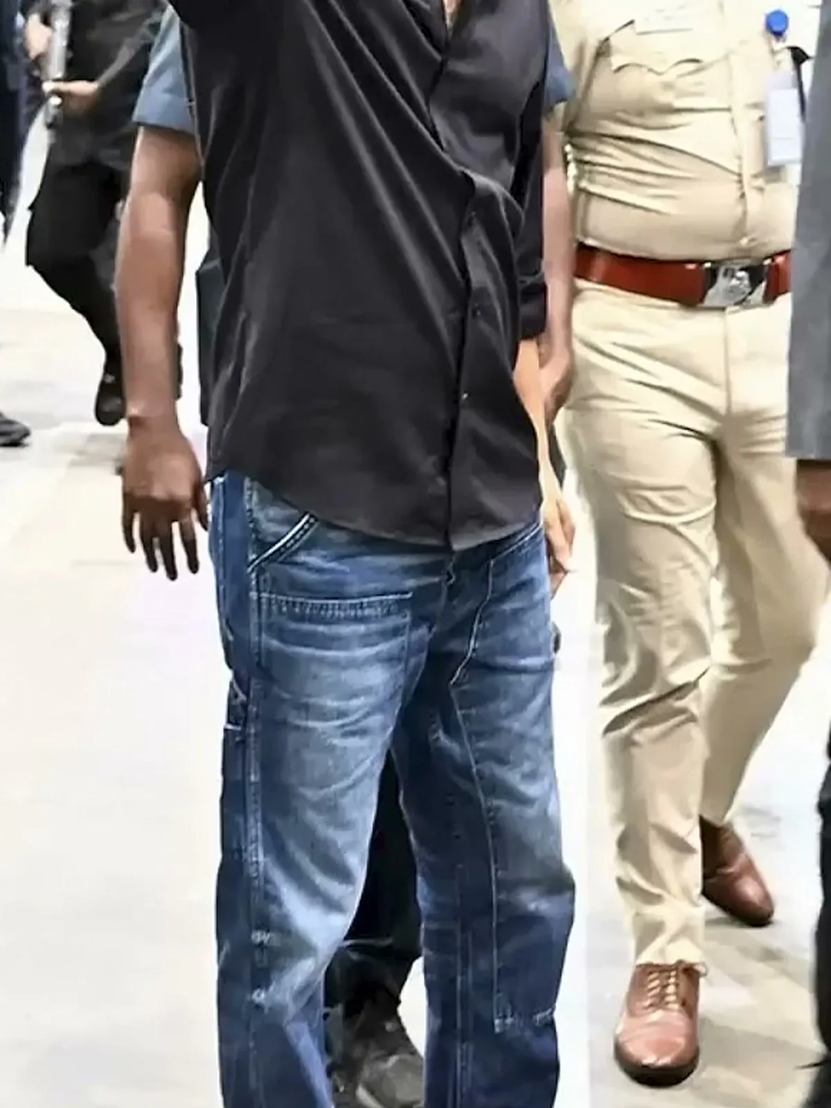 Vijay — Worn untucked over the jeans: the shirt hem, and the whiskering across the thigh