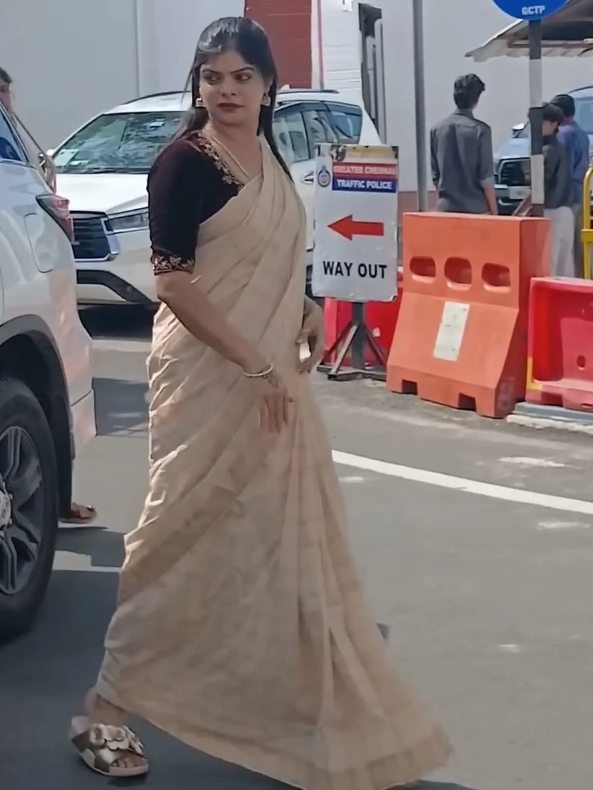 Kanimozhi Santhosh — The whole look — sand tissue saree, wine zari-trimmed blouse, and the gold flower slides at the hem