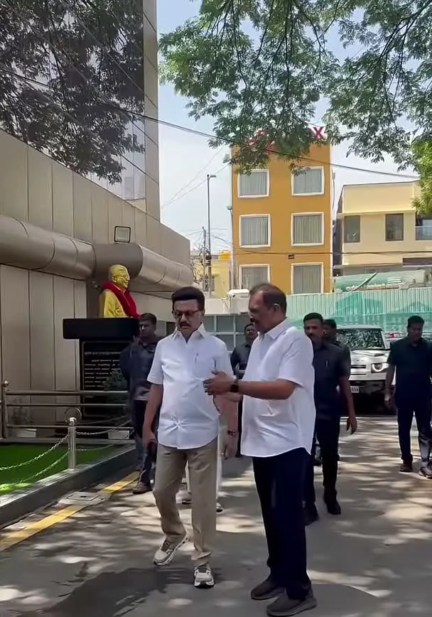 Vijay — Full length outdoors — the same shirt and chinos, a different setting