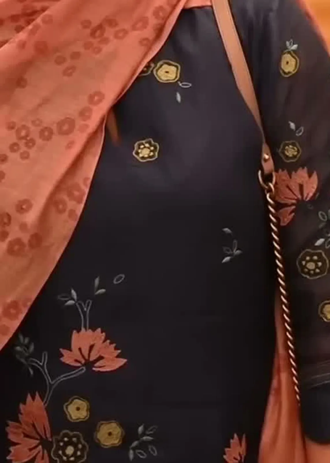 Keerthy Suresh — Close on the kurta: the salmon lotus appliqué, the olive-mustard rosettes and the pale teal leaf sprigs, with a lot of plain navy between them