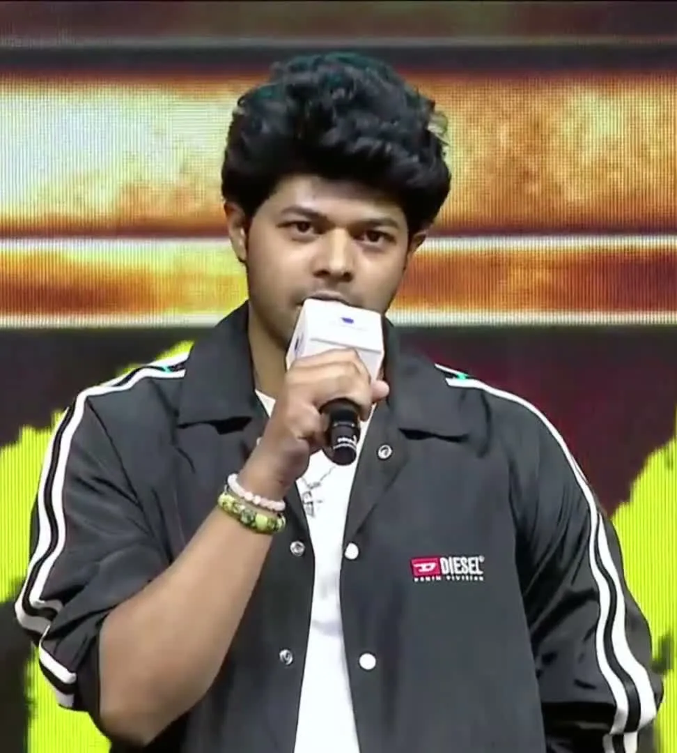 Jason Sanjay — On stage with the mic: the DIESEL patch at the left chest and both bracelets on the right wrist
