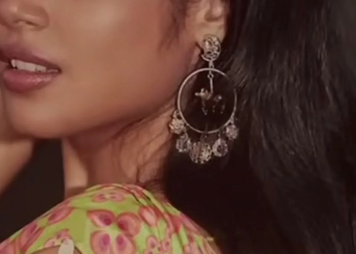 Faria Abdullah — The earring close up — a silver hoop from a floral stud, a small figure inside the ring, ghungroo bells round the rim
