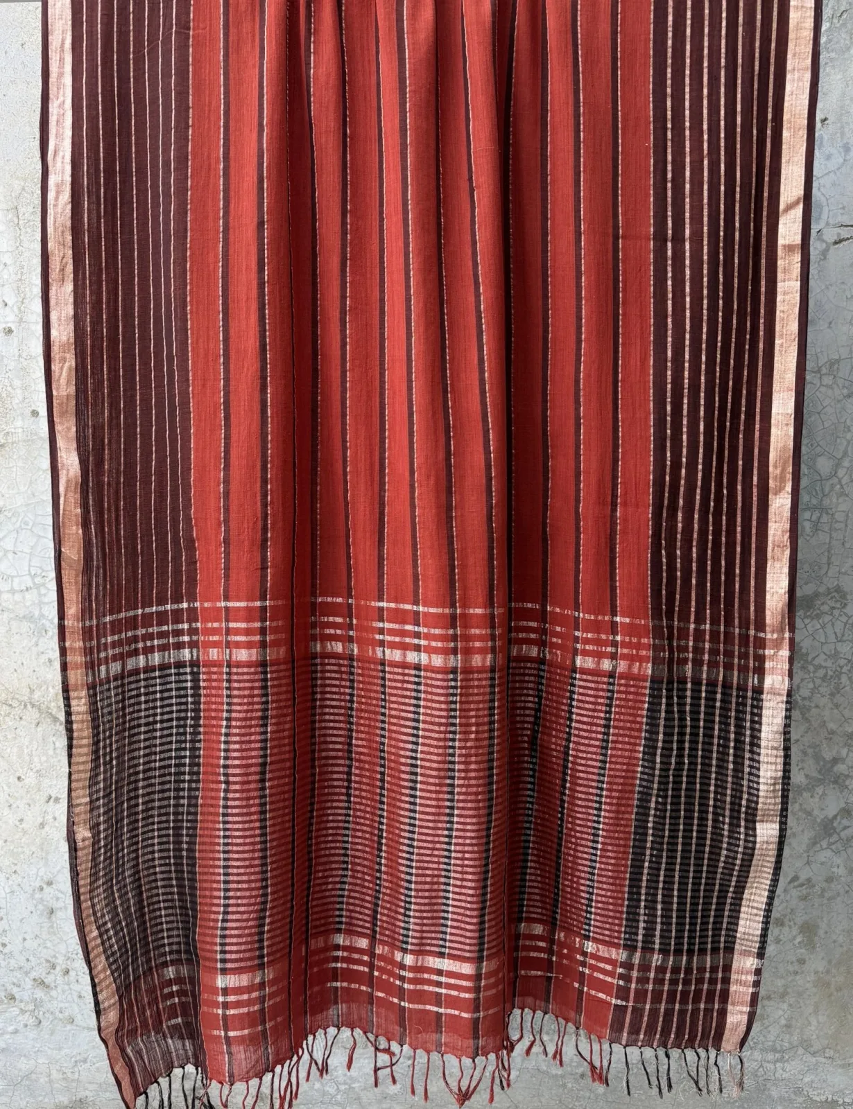 Rust saree with indigo stripe band and gold-striped border